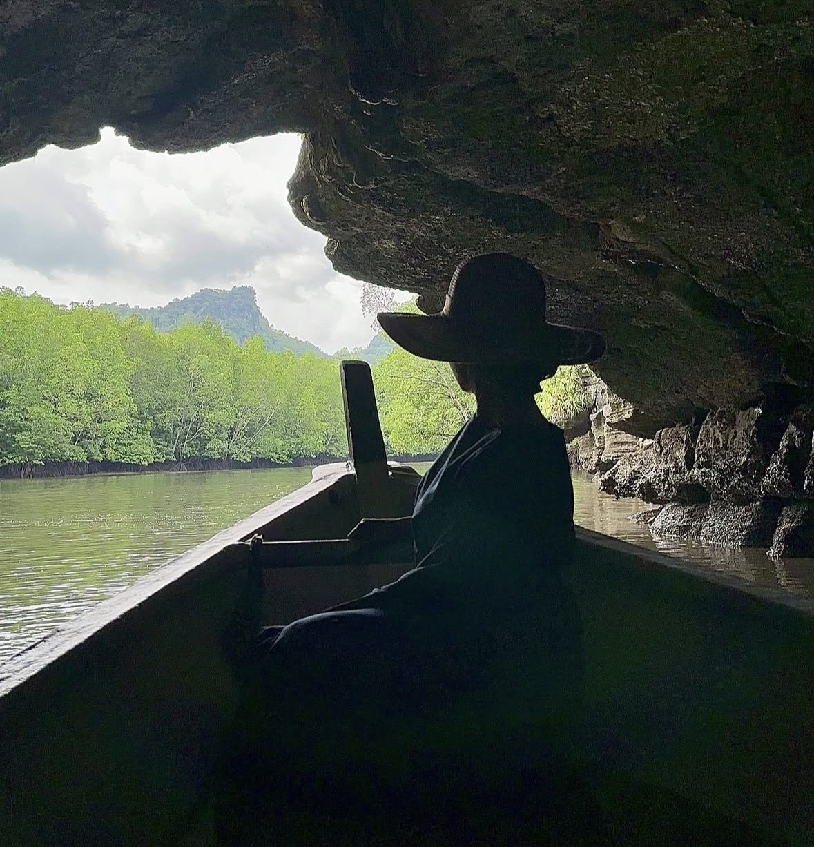 Boat cruising through lush mangrove forest in Kilim Geoforest Park Langkawi