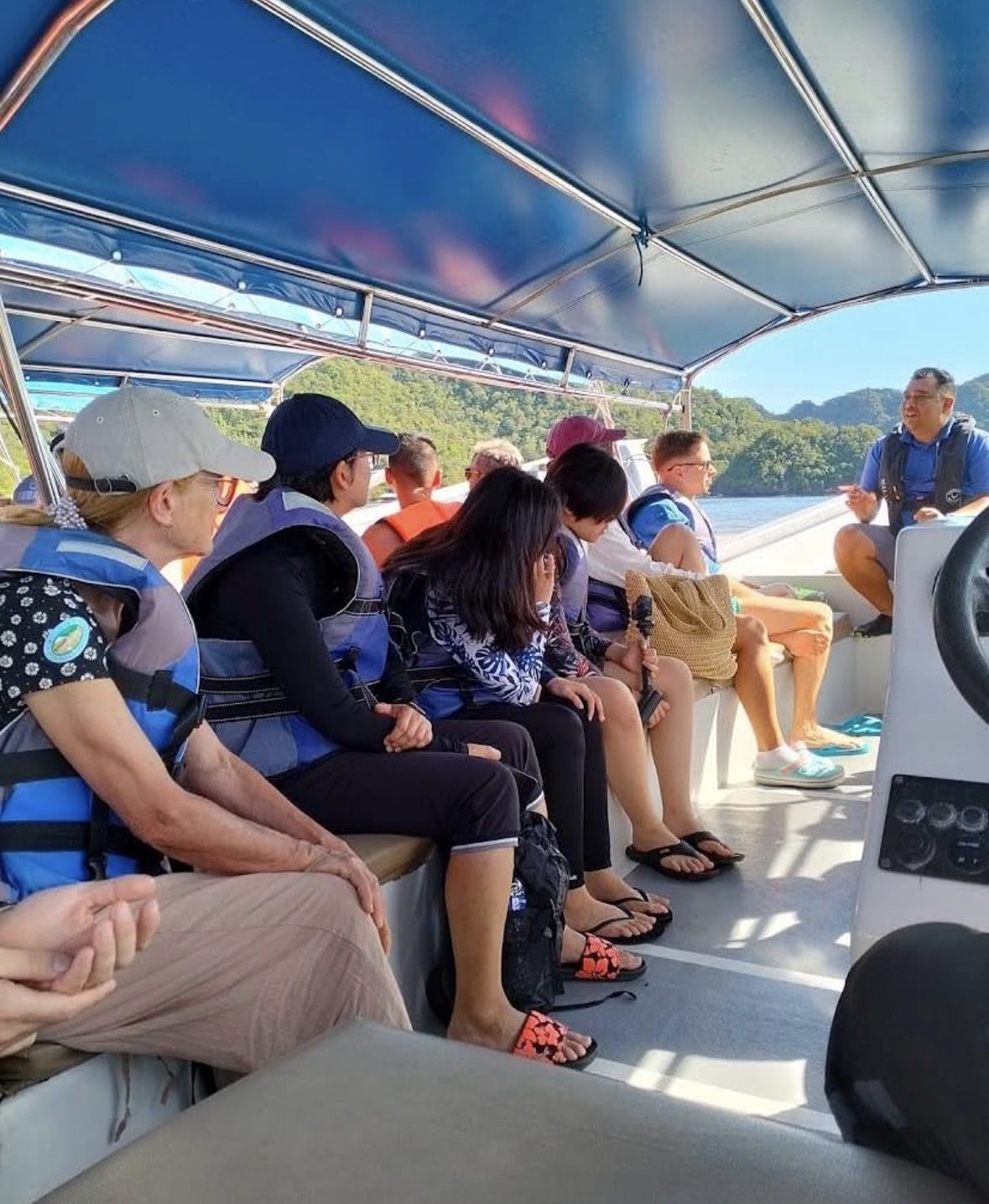 Langkawi mangrove tour guide explaining ecosystem to tourists on private boat